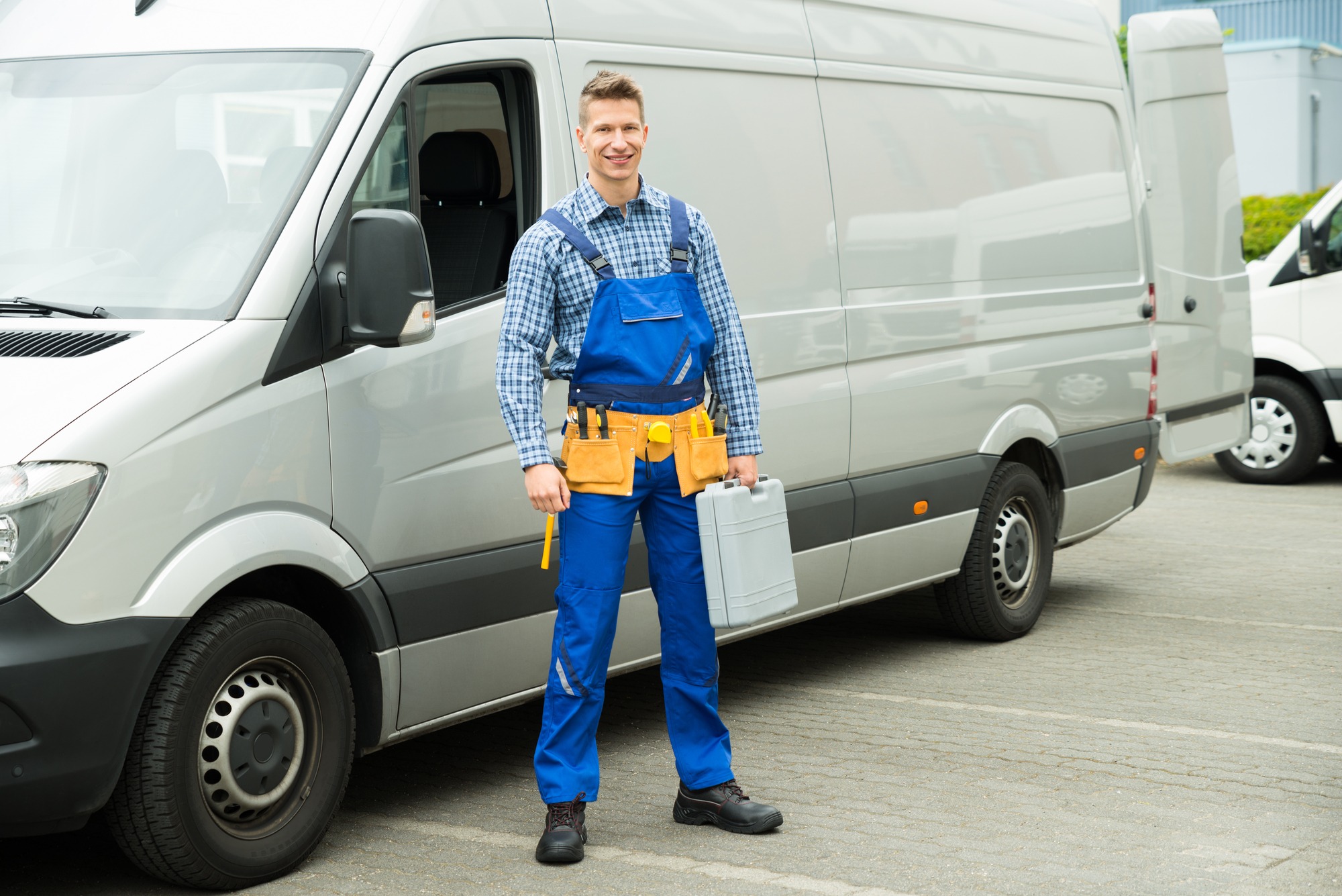 Young Electrician With Tools And Toolbox Standing In Front Of Service Van.